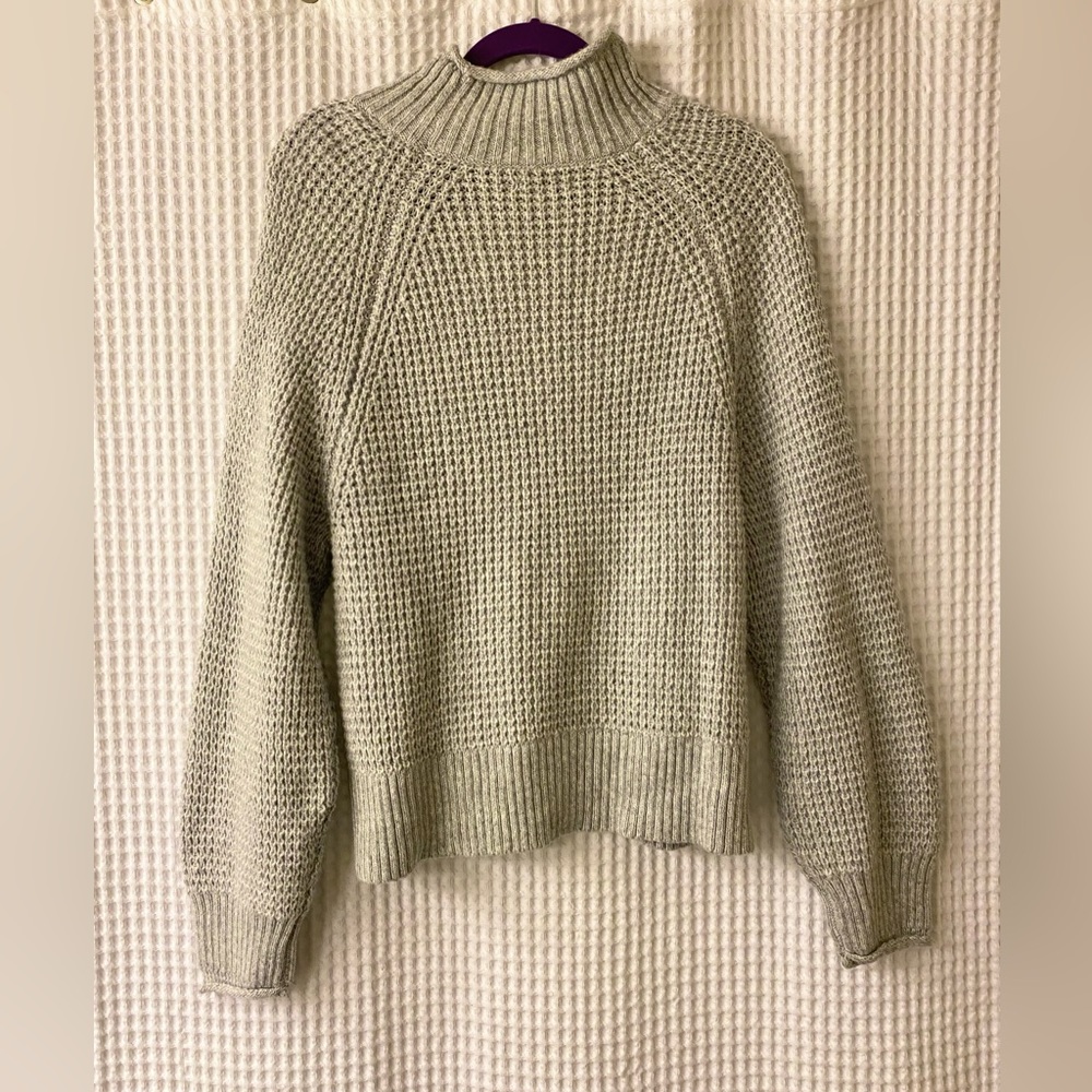 Gray knitted, long sleeved shirt with turtleneck.